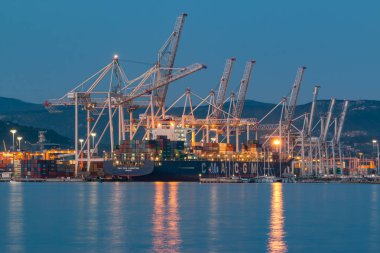 Koper, Slovenya - 19 Nisan 2019: Konteyner gemisi akşam geç saatlerde Koper uluslararası deniz limanında boşaltılıyor