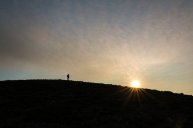 Hırvatistan 'ın Velebit Masif kentindeki Alancic Dağı' nın tepesinden yükselen bir adamın silueti.