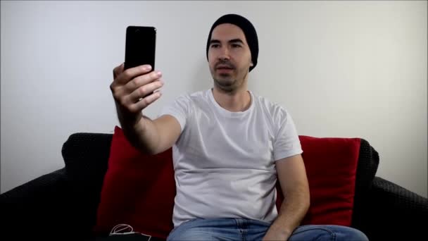 Jeune Homme Assis Sur Canapé Accueil Contenu Créateur Tenir Smartphone — Video