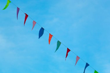 Renkli üçgen bayrakları mavi gökyüzü ile çapraz.