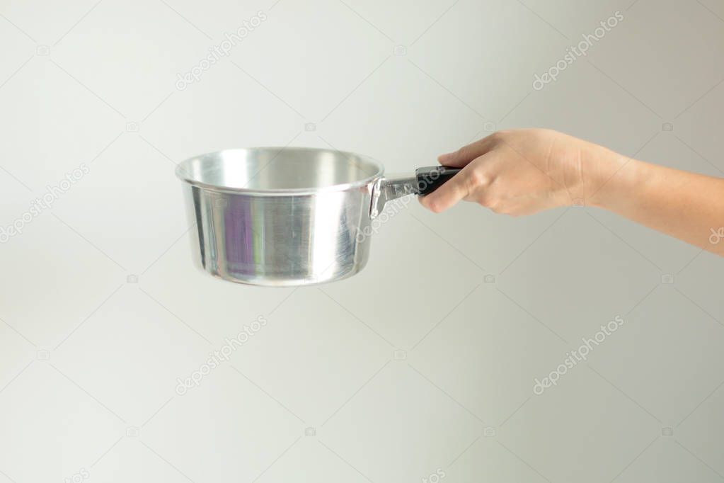 A Hand hold a handle of stainless pot prepare for cooking, on white background.