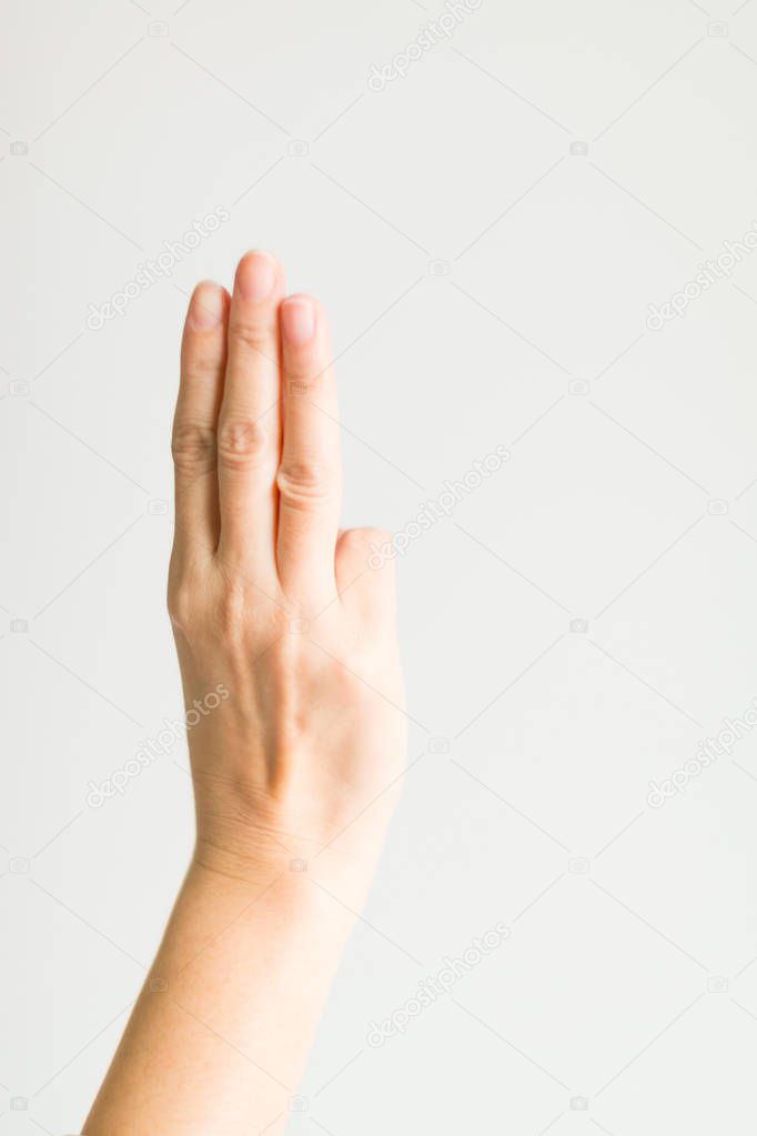 Hand sign showing three fingers (index finger, middle finger and ring finger) on white background.