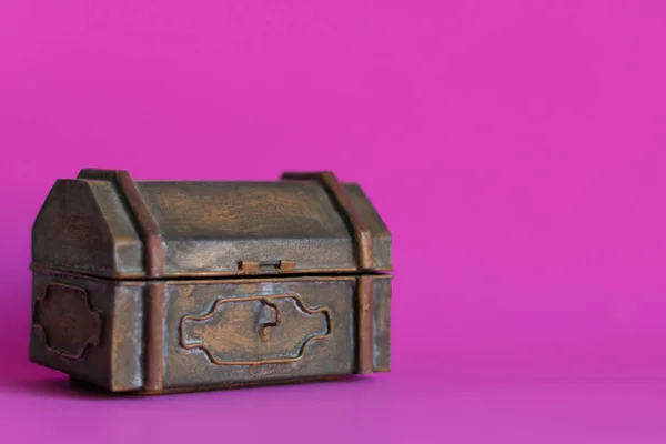 An old vintage metal chest box on pink background with copy space.