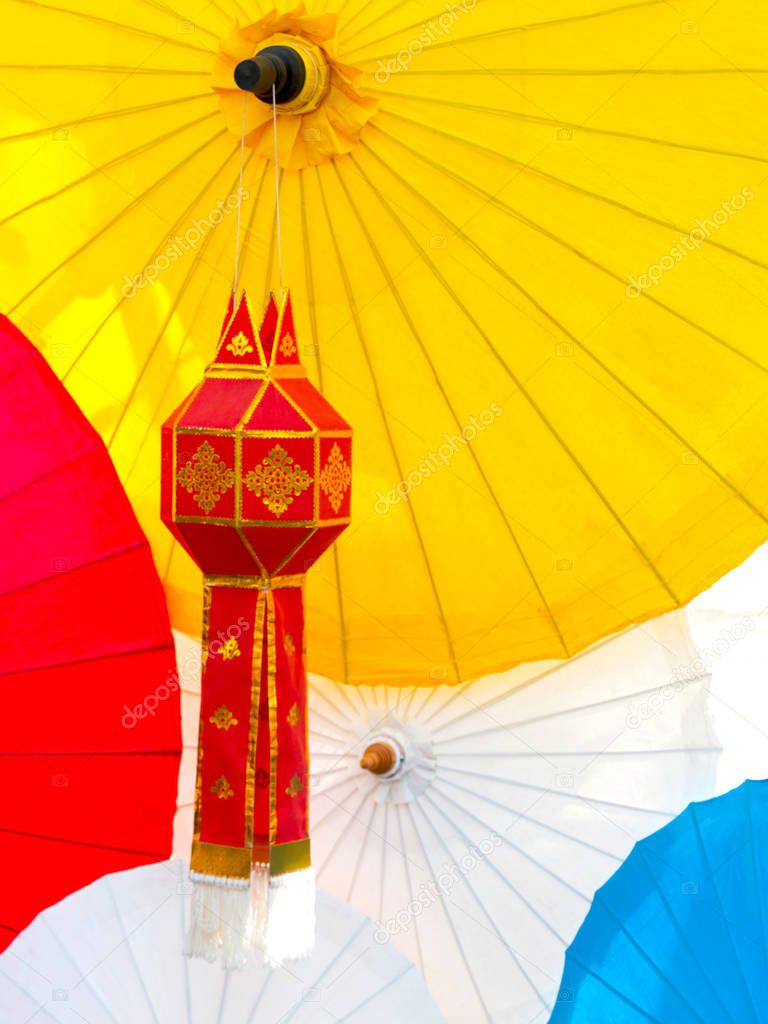 Red Lanna lantern with background of colorful lanna umbrellas.