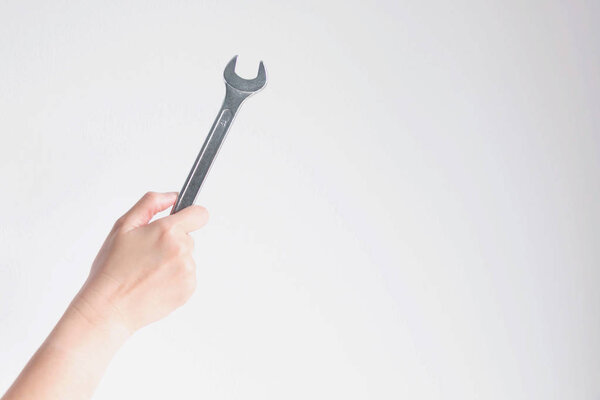 hand holding a wrench on white background