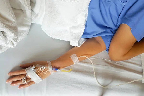 Hand van de patiënt met druppelaar infusie naald voor intraveneuze infusie. — Stockfoto