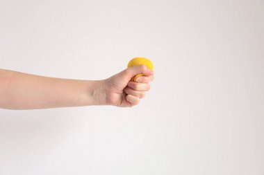 Egzersiz el kas ve parmaklar için sarı squishy topu basarak el; ve stres yorgunluk hissi için; Sağlık ve tıbbi kavramı.