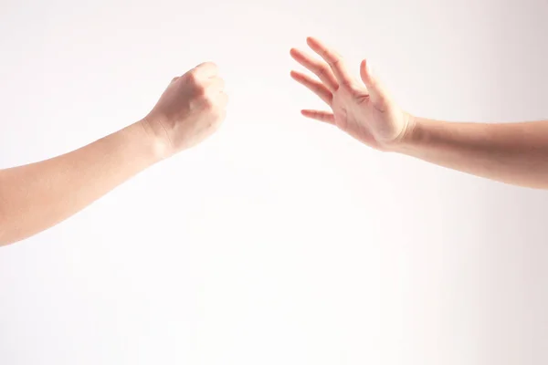 Dvě osoby hrající na papír; jednou rukou se symbolem skály nebo kladiva a jinou rukou zobrazující symbol papíru; Koncepce hospodářské soutěže. — Stock fotografie