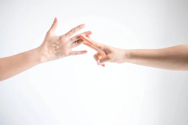 Zwei Personen, die Steinpapierscheren spielen; eine Hand zeigt Papiersymbol und eine andere Hand zeigt Scherensymbol; Konzept des geschäftlichen Wettbewerbs. lizenzfreie Stockfotos