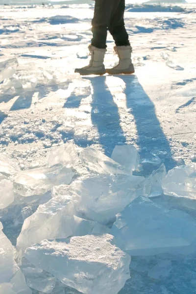 Benen van de toerist in de Sneeuwlaarzen wandelen langs bevroren meer Baikal in de winter. — Stockfoto