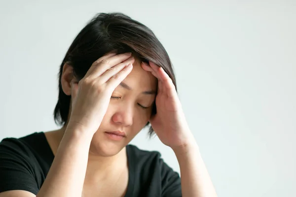En kvinna i huvudvärk; Använd två händer håll temporals och Stäng hennes ögon. — Stockfoto