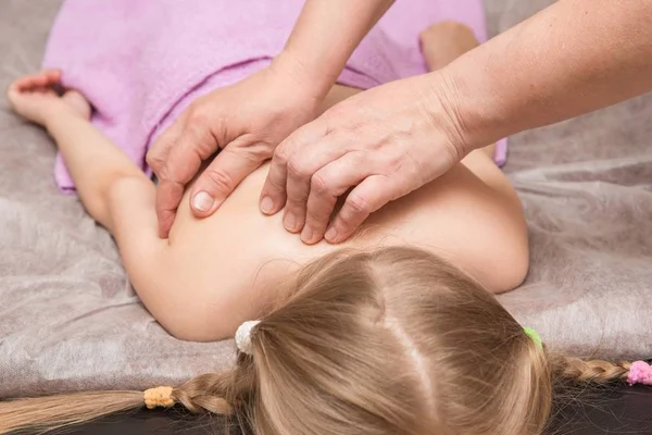 masör çocuk bir sırt masajı verir.