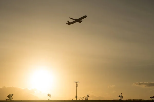 Silhouette of a plane taking off from the airport at sunset airport