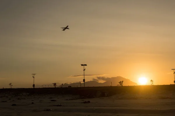 Silhouette of a plane taking off from the airport at sunset airport