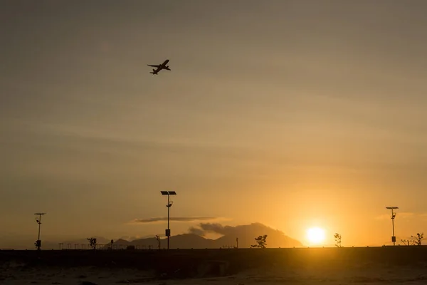 Silhouette of a plane taking off from the airport at sunset airport