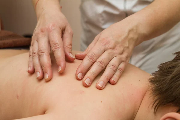 The masseur gives the child a back massage — Stock Photo, Image
