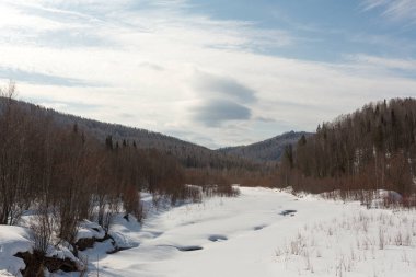 Karla kaplı ormanda donmuş nehir, kar ile kaplı arka planda ağaçlar, gökyüzünü görebilirsiniz, gündüz güzel doğa, ormanda kış