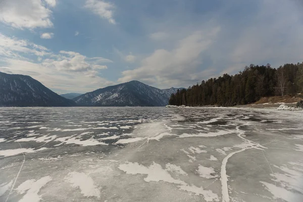 Veduta di bellissimi disegni su ghiaccio da crepe sulla superficie del lago Teletskoye in inverno, Russia — Foto Stock