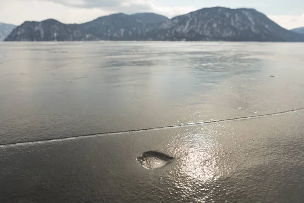 Veduta di bellissimi disegni su ghiaccio da crepe sulla superficie del lago Teletskoye in inverno, Russia — Foto Stock