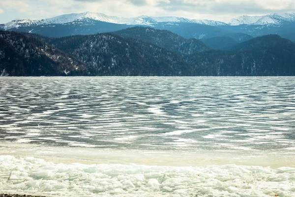 Veduta di bellissimi disegni su ghiaccio da crepe sulla superficie del lago Teletskoye in inverno, Russia — Foto Stock