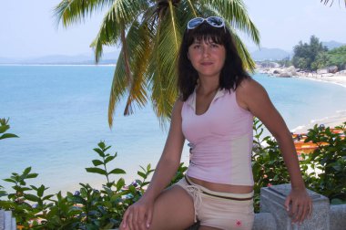 Esmer, kumsalda meditasyon yaparken taş basamaklarda bir palmiye ağacının altında..