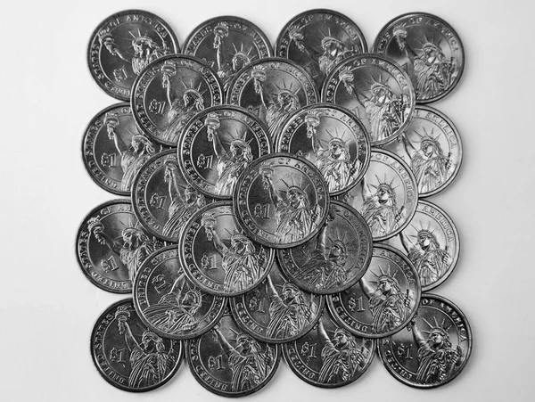 Design element. Pyramid of shiny coins of one US dollar. View from above.  On a white background. Black and white.