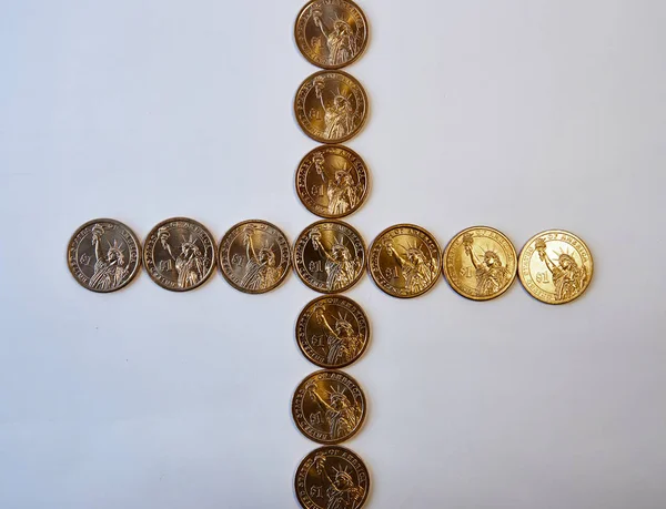 Elemento de design. Cruz reta de moedas de brilho amarelo um usd. Vista de cima. Em um fundo branco . — Fotografia de Stock