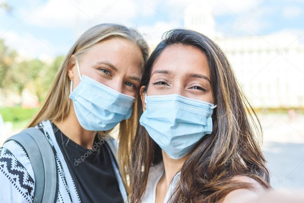 Self portrait of an indian woman with a caucasian friend, both with surgical blue masks