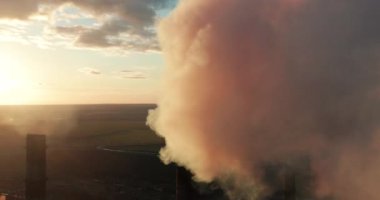 Gün batımında havada borulardan siyah duman çıkıyor. Çevre kirliliği. Büyük endüstriyel fabrika boruları kimyasal duman üretir..