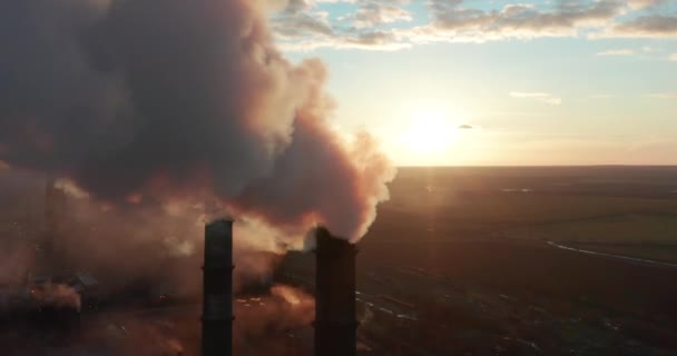 Vista aérea. Tubos jogando fumaça no céu ao pôr do sol . — Vídeo de Stock