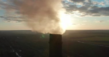 Gün batımında havada borulardan siyah duman çıkıyor. Çevre kirliliği. Büyük endüstriyel fabrika boruları kimyasal duman üretir..