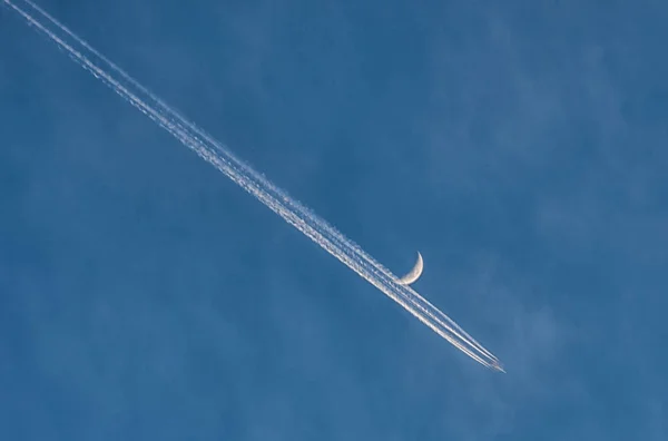 Airplane flies past the moon