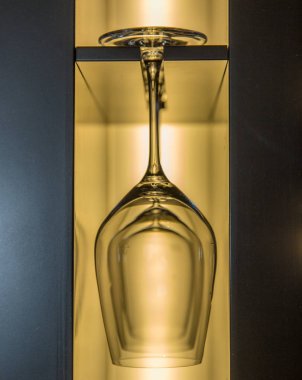 Şarap kadehi, rafta sarıyla aydınlatılmış.