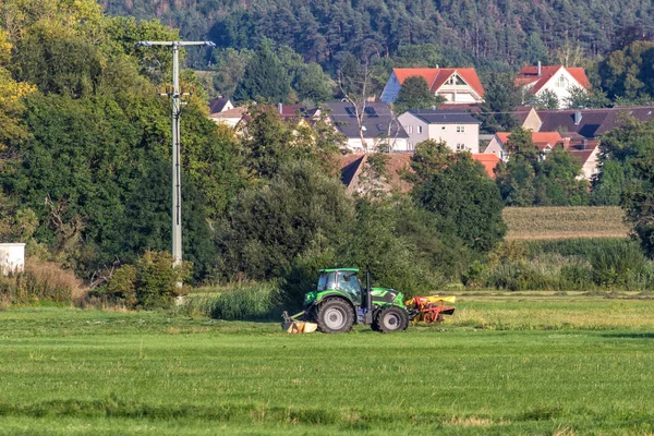 Trekker Auf Einem Feld Mit Einem Kleinen Dorf Hintergrund — Stockfoto