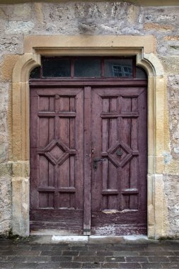 Kahverengi, taş merdivenli eski ahşap kapı.