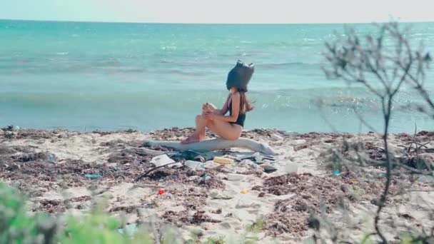 Flicka Med Svart Plastpåse Huvudet Sitter Karibisk Strand Bland Plast — Stockvideo