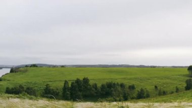 Tüylü otlar rüzgarda sallanıyor nehrin yakınındaki bir uçurumda