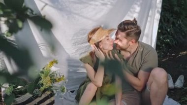 Genç karı koca bahçede birlikte dinleniyorlar.