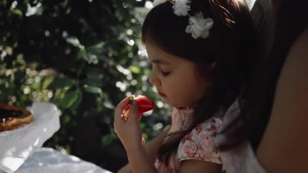 庭でイチゴを食べる少女 — ストック動画