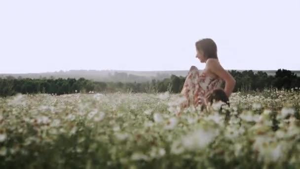 Dívka Šatech Běží Přes Sedmikrásky Pole Při Západu Slunce — Stock video
