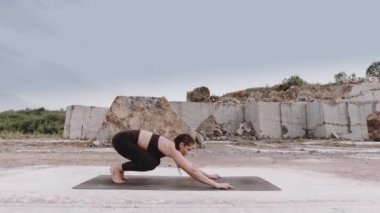 Yogacı kız Sibirya 'da gün doğumunda mermer ocağında egzersiz yapıyor.