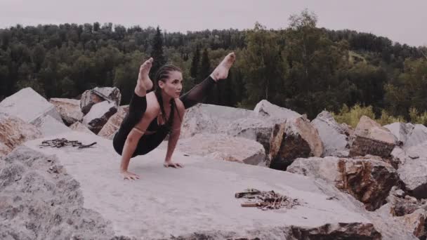 西伯利亚 一名瑜伽女孩在靠近篝火的黎明时分在一个大理石采石场进行训练 — 图库视频影像