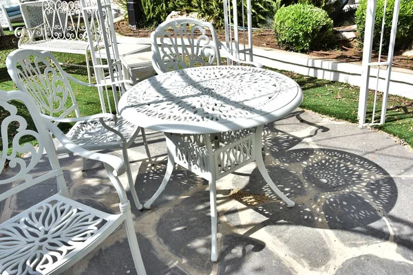 Letní jemný dekorativní nábytek v zelené zahradě, stůl a židle pro novomanžele a hosty na svatbě — Stock fotografie
