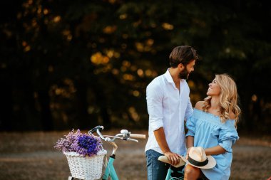 Genç bir çift bir bisiklet sürme bir mola sırasında birbirlerinin gözlere bakmak portresi.