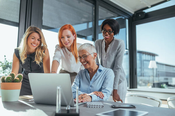 Businesswomen working together in the office on a project. 