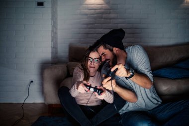 Genç çift video oyunları evde oynarken rekabet fotoğrafı.