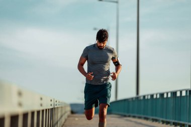 Köprüde çalışan ve müzik sporcu adam.