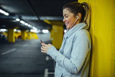 Bir egzersiz yaptıktan sonra müzik dinlerken rahatlatıcı bir harika sporcu kadın görüntüsünü.