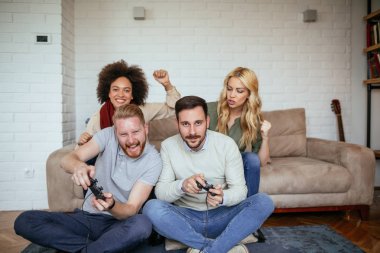 Arkadaşlar eğlenmeye video oyunları oynarken.