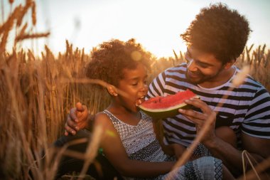 Karpuz alanında ile onun kızının beslenme bir Afrikalı-Amerikalı babası portresi kapatın.